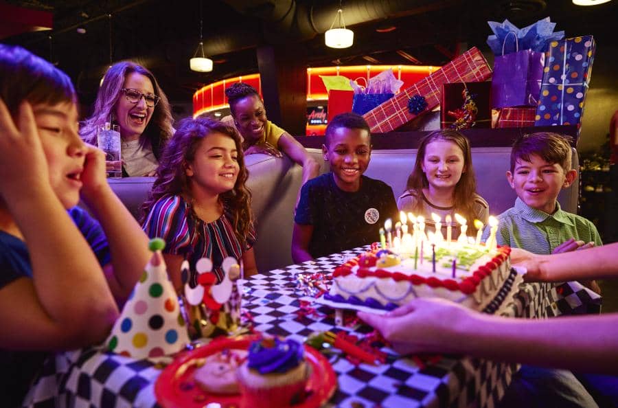 Andy B's hosts a birthday party with a cake and smiling children.